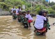 Satgas TNI Bantu Anak-Anak Kampung Dal Seberangi Sungai Berangkat Ke Sekolah