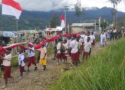 Pengibaran Bendera Merah Putih Di Bukit Sion Dan Kirab Oleh Satgas Habema Dengan Masyarakat Sinak Warnai Kemeriahan Peringatan HUT Kemerdekaan RI