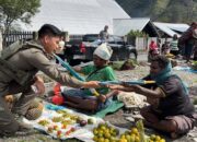 Senyum Mama-Mama Papua Saat Bripda. Rafly Personel Ops Damai Cartenz-2025 Ulurkan Payung